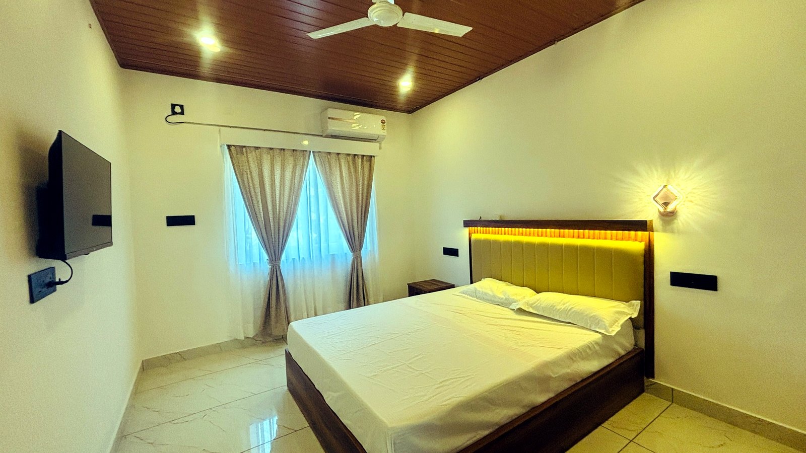 Kerala Spices Homestay bedroom with double bed curtains and wooden ceiling