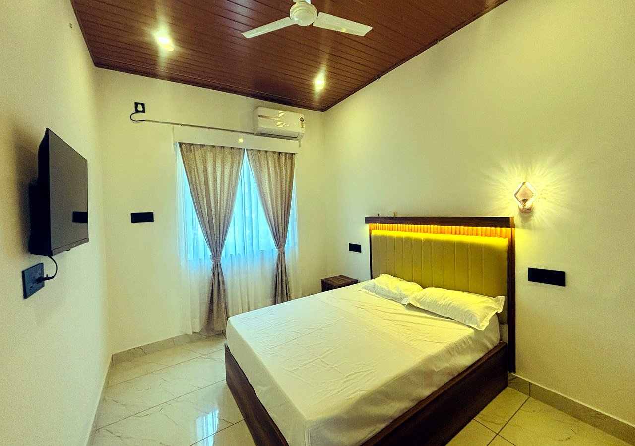 Kerala Spices Homestay double room with ceiling fan curtains and TV